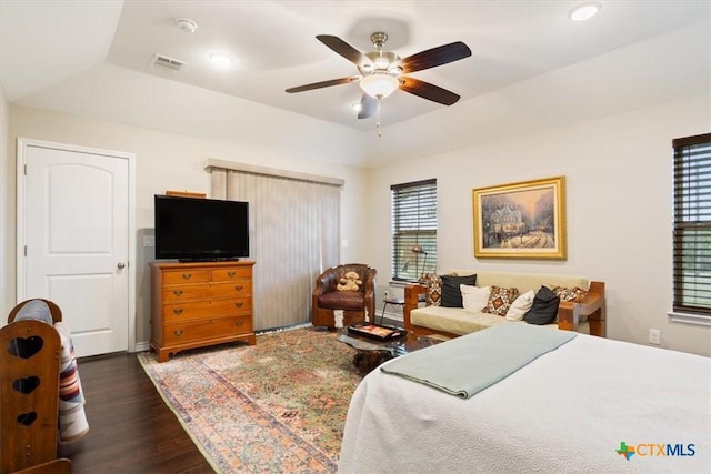 bedroom featuring dark hardwood / wood-style flooring, ceiling fan, and a tray ceiling