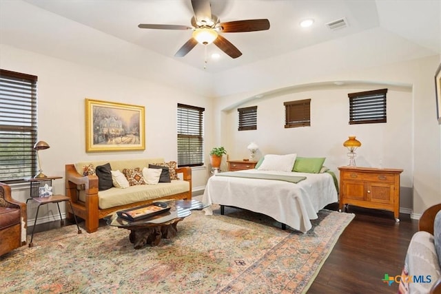 bedroom with ceiling fan, dark wood-type flooring, and a tray ceiling