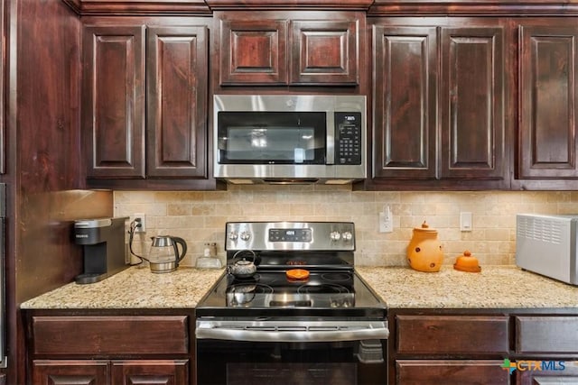 kitchen featuring stainless steel appliances, decorative backsplash, dark brown cabinets, and light stone countertops