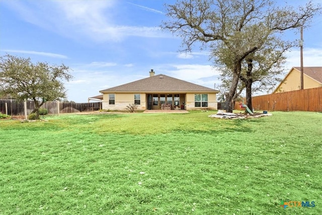 rear view of house with a lawn and a patio