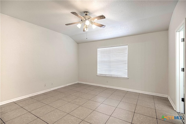 tiled empty room featuring a textured ceiling, lofted ceiling, and ceiling fan