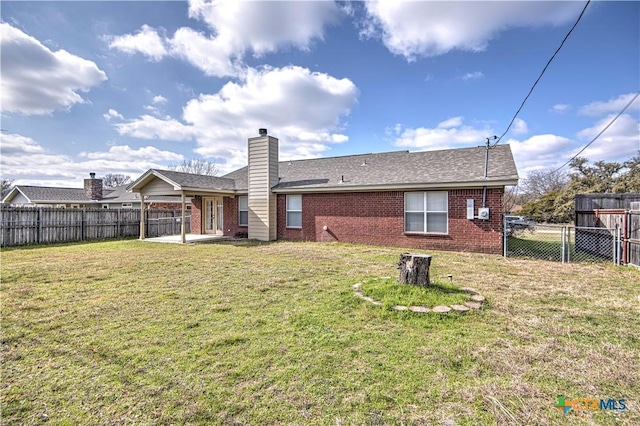 rear view of house featuring a yard and a patio