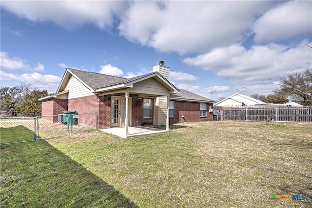 back of house featuring a lawn and a patio area