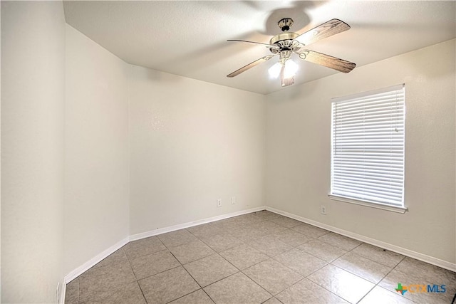 tiled spare room with ceiling fan