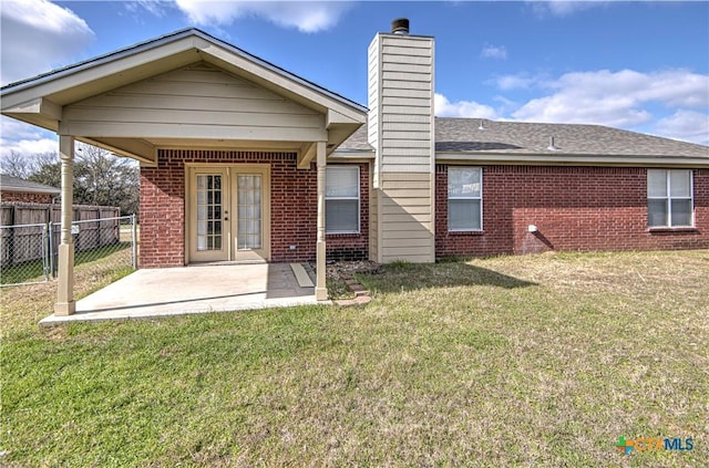 back of property featuring a patio area and a yard