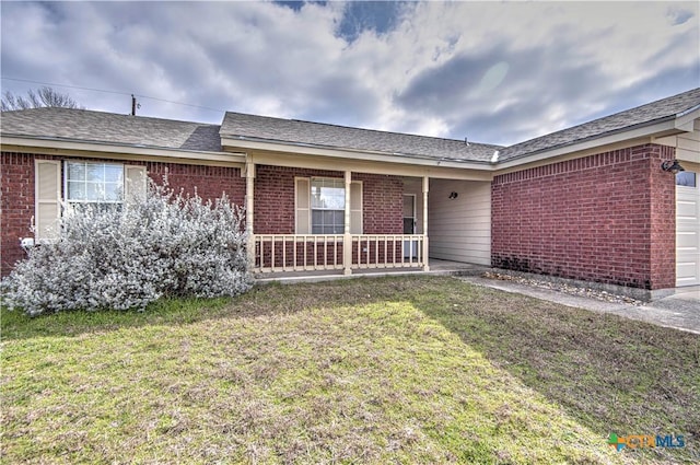 view of front of home with covered porch and a front lawn