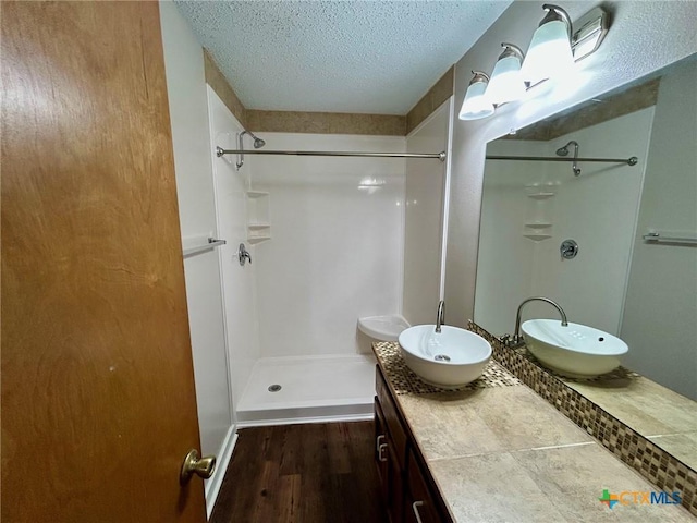101 Chantilly St, Victoria, TX 77904 - bathroom featuring a shower stall, wood finished floors, a textured ceiling, and vanity