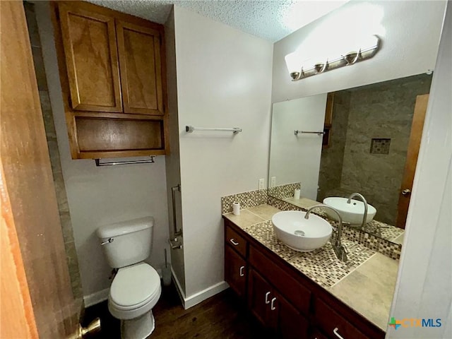 101 Chantilly St, Victoria, TX 77904 - bathroom with toilet, vanity, wood finished floors, a textured ceiling, and baseboards