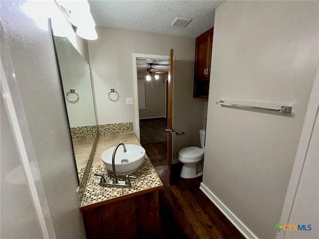 101 Chantilly St, Victoria, TX 77904 - bathroom featuring toilet, wood finished floors, vanity, ceiling fan, and a textured ceiling