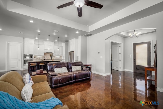 750 Cambridge Dr, New Braunfels, TX 78132 - living area featuring baseboards, concrete flooring, arched walkways, a chandelier, and ceiling fan