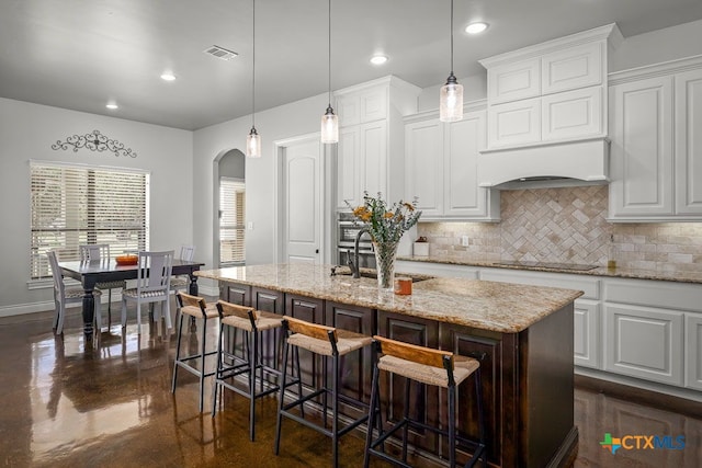 750 Cambridge Dr, New Braunfels, TX 78132 - kitchen with arched walkways, tasteful backsplash, a sink, finished concrete floors, and black electric stovetop