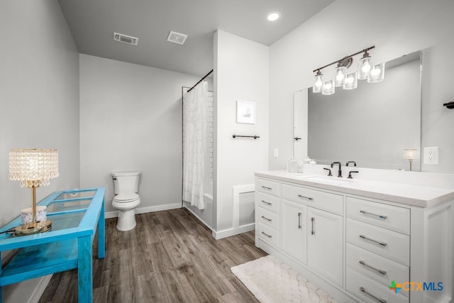 750 Cambridge Dr, New Braunfels, TX 78132 - full bathroom with vanity, wood finished floors, toilet, baseboards, and a shower with shower curtain