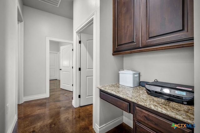 750 Cambridge Dr, New Braunfels, TX 78132 - kitchen with baseboards, concrete flooring, dark brown cabinetry, and light stone counters