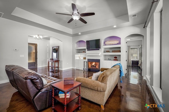 750 Cambridge Dr, New Braunfels, TX 78132 - living room featuring arched walkways, built in shelves, a tray ceiling, baseboards, and recessed lighting