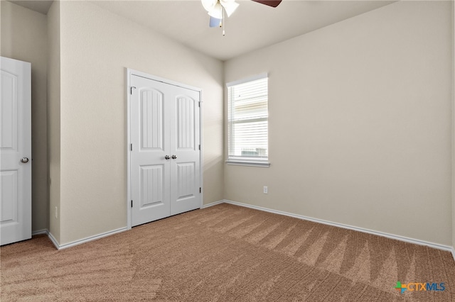 unfurnished bedroom with ceiling fan, a closet, and carpet