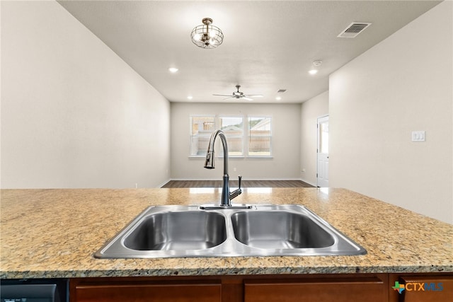 kitchen with ceiling fan, sink, and wood-type flooring