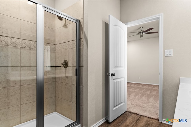 bathroom with ceiling fan, walk in shower, and wood-type flooring