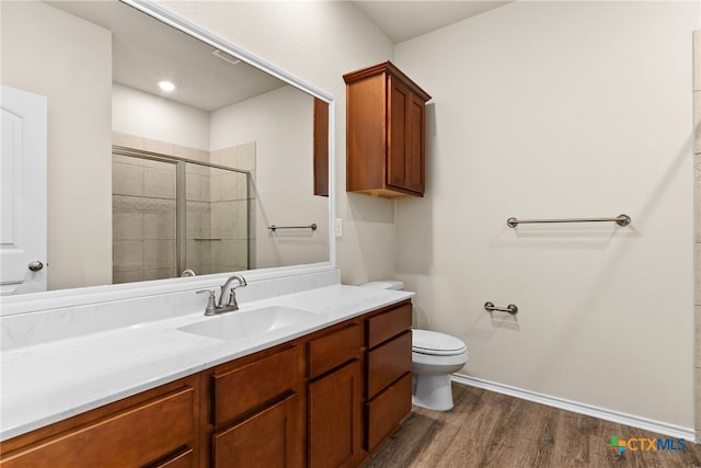 bathroom featuring hardwood / wood-style floors, walk in shower, vanity, and toilet