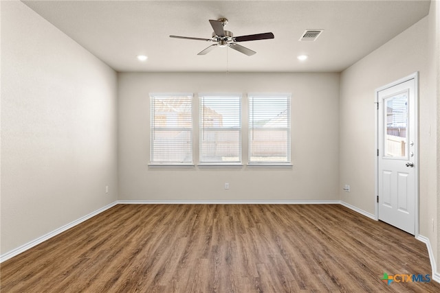 unfurnished room with ceiling fan, a wealth of natural light, and wood-type flooring