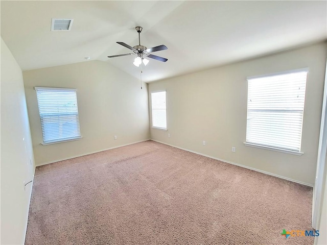 spare room with visible vents, a ceiling fan, carpet flooring, vaulted ceiling, and baseboards