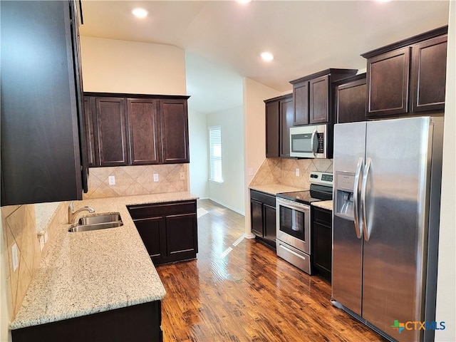 kitchen with a sink, dark brown cabinetry, stainless steel appliances, and dark wood-type flooring