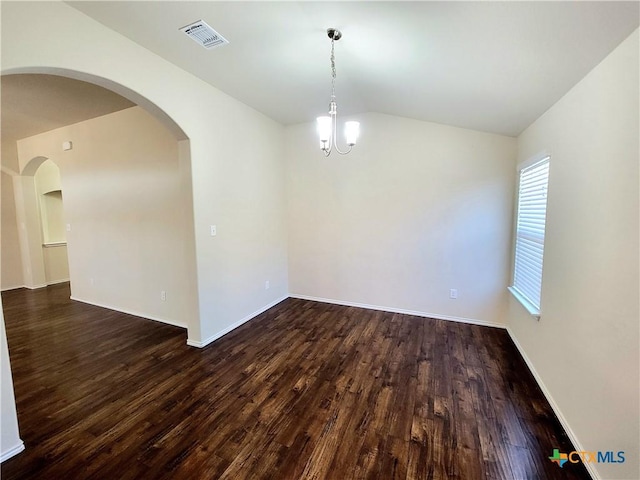 spare room featuring vaulted ceiling, dark wood-type flooring, visible vents, and baseboards