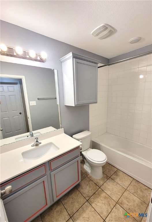 bathroom featuring visible vents, toilet, vanity, a textured ceiling, and tile patterned flooring