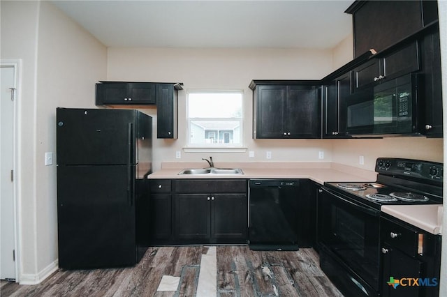704 S Vine St, Victoria, TX 77901 - kitchen with black appliances, a sink, dark cabinets, dark wood-style flooring, and light countertops