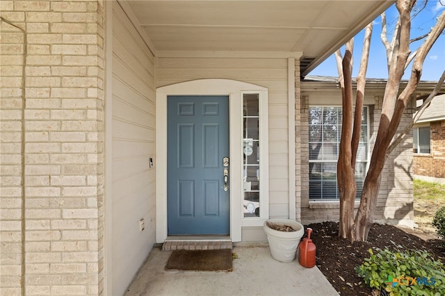 view of exterior entry featuring brick siding