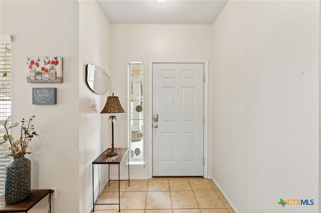 entryway with light tile patterned flooring and baseboards