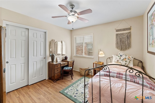 bedroom with a closet, light wood-style flooring, baseboards, and a ceiling fan