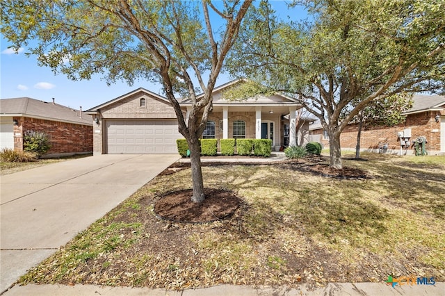 view of front of home with brick siding, an attached garage, and driveway