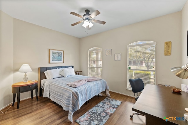 bedroom with ceiling fan, baseboards, and wood finished floors