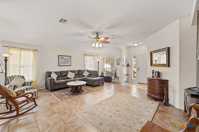 living room featuring light tile patterned flooring, visible vents, baseboards, and a ceiling fan