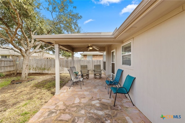 view of patio / terrace with ceiling fan and fence