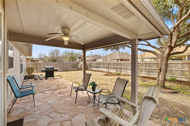 view of patio featuring area for grilling, a fenced backyard, and a ceiling fan