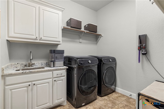 laundry area with cabinets, light tile patterned flooring, separate washer and dryer, and sink