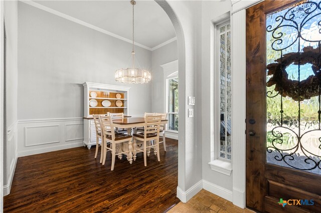 dining space featuring hardwood / wood-style floors, a chandelier, and crown molding