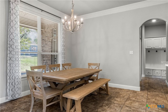 tiled dining room featuring plenty of natural light, an inviting chandelier, and ornamental molding