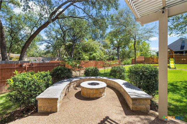 view of patio featuring a playground and an outdoor fire pit