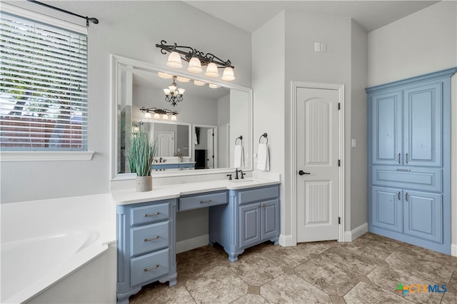 bathroom featuring a bath, vanity, and a notable chandelier