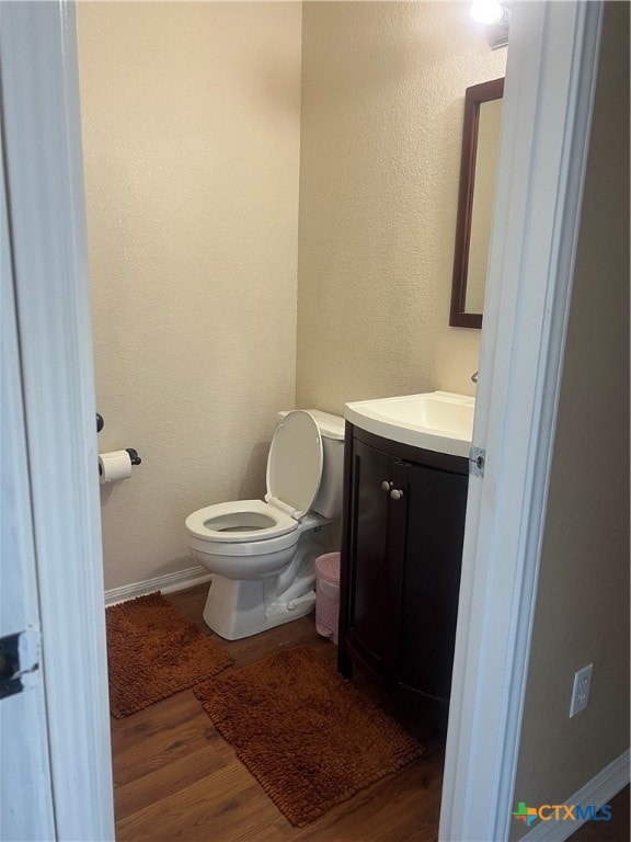 bathroom featuring hardwood / wood-style flooring, vanity, and toilet