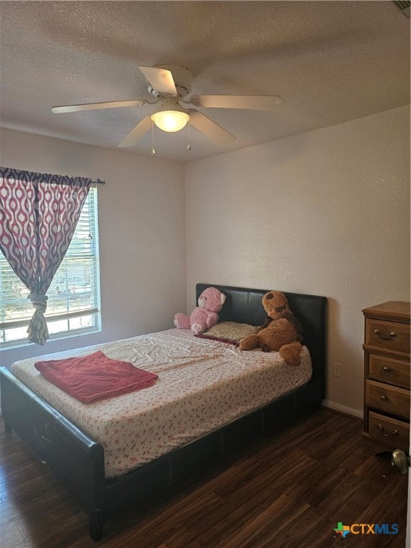 bedroom with ceiling fan, dark hardwood / wood-style floors, and a textured ceiling