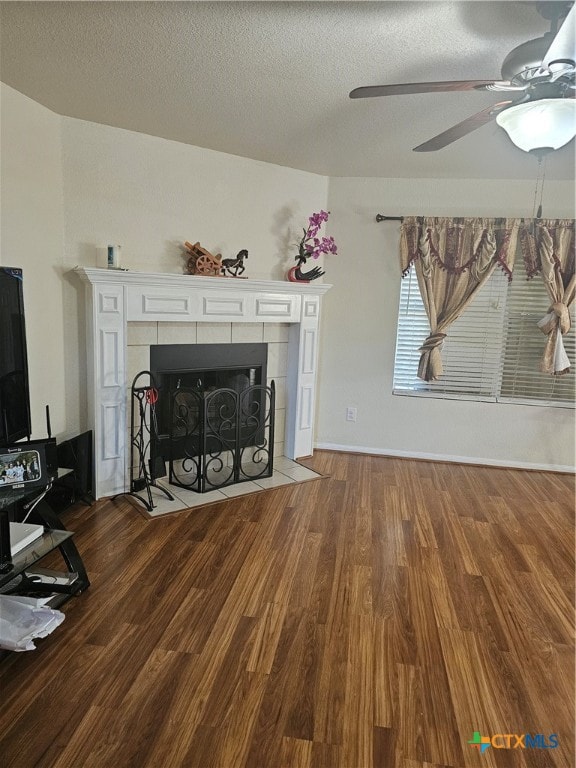 unfurnished living room featuring a fireplace, a textured ceiling, hardwood / wood-style flooring, and ceiling fan