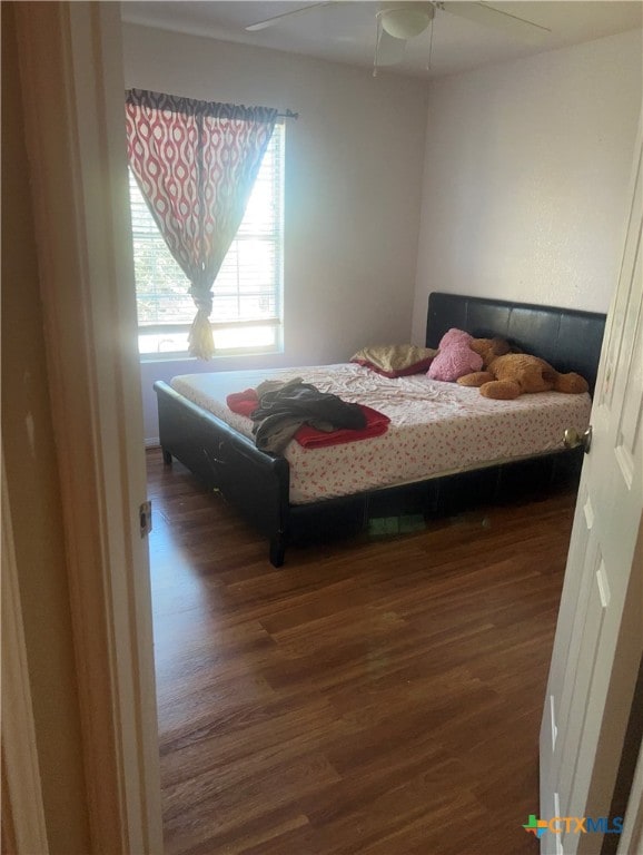 bedroom with ceiling fan and dark hardwood / wood-style flooring