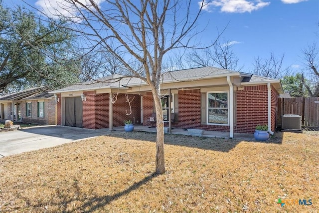 single story home with brick siding, central air condition unit, concrete driveway, an attached garage, and fence