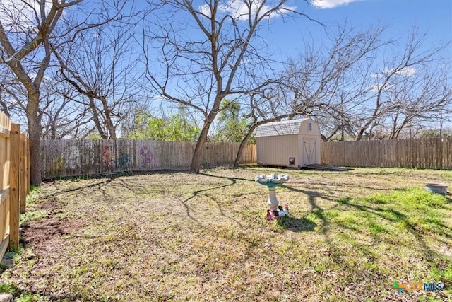 view of yard with an outbuilding, a shed, and a fenced backyard