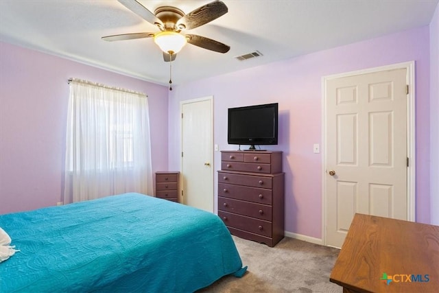 carpeted bedroom featuring baseboards, visible vents, and a ceiling fan