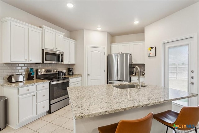 3703 Mccleland Creek Trl, Temple, TX 76502 - kitchen with appliances with stainless steel finishes, a sink, a breakfast bar, white cabinets, and recessed lighting