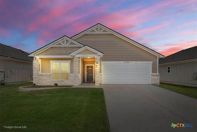 3703 Mccleland Creek Trl, Temple, TX 76502 - view of front facade with stone siding, concrete driveway, a lawn, and an attached garage